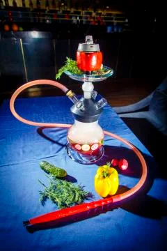 Hookah on vegetables. Hookah with a round transparent flask, which contains c Stock Photos