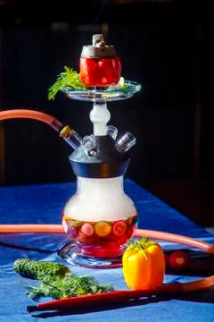 Hookah on vegetables. Hookah with a round transparent flask, which contains c Stock Photos