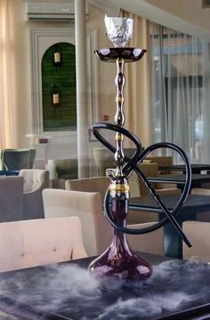 Hookahs shisha on table in restaurant interior. Space for text Stock Photos