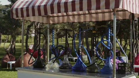Hookahs with water stand in a row on a counter in the park with a recreation Video stock 337120319
