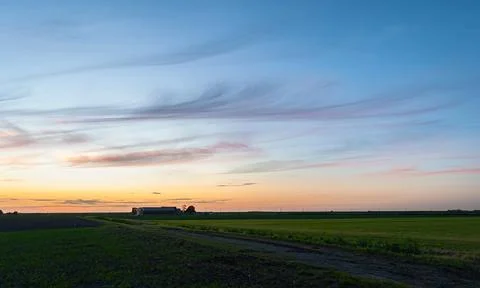 Hooked cirrus clouds above plain landscape Stock Photos