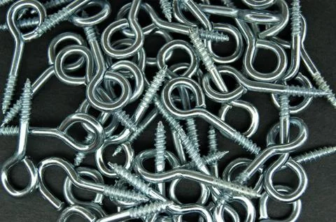 Hooked screw rings on a dark background. Construction. Stock Photos