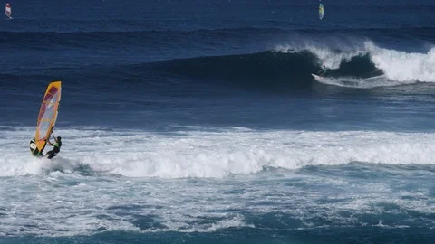 Hookipa Surfer and Windsurfer sharing waves 4k 60p slow motion Stock Footage 109395550