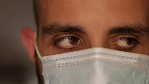 Hope concept: Masked man is scared about coronavirus. Moves eyes Stock Footage 136424803