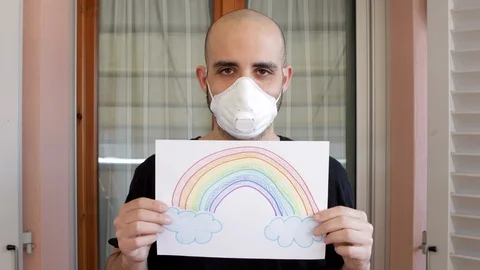 Hope concept: young man with virus mask and rainbow drawing is sad, then smile Video stock 126823770