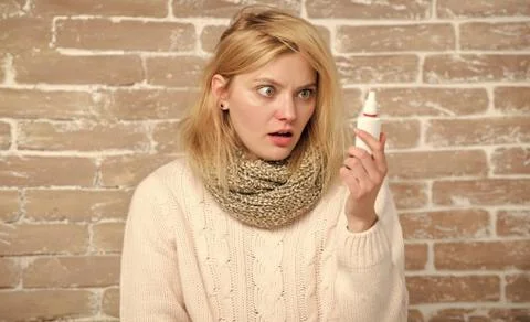 Hope it will help me. Pretty girl with runny nose holding nasal drops. Sick Foto stock