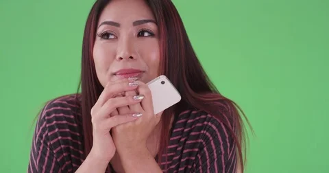 Hopeful Asian woman waiting for her date on green screen Stock Footage