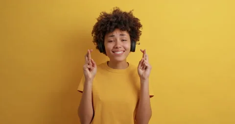 Hopeful curly young pretty Afro American woman crosses fingers for good luck Stock Footage 151194792