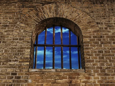 Hopeful view thru the prison window on wall to cloudy sky Stockbeeldmateriaal 74744517