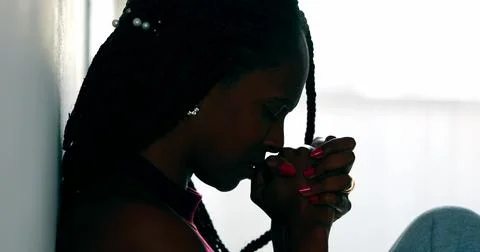 Hopeful woman praying that life will get better. Black African female prayer Stock Photos