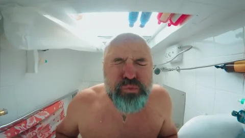 Hopeless bearded man lowering head into bathtub water and starting to scream Stock Footage 346285358
