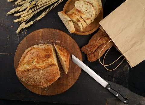 Hopped grain bread put on kitchen wood plate with knife for cut. Fresh brea.. Stock Photos