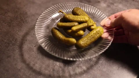 Horizontal 4K video. 60 fps. Male hand puts plate of small green gherkins Stock Footage 326825733