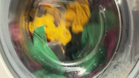 Horizontal 4K video close up. 60 fps. Wet clothes is spinning in drum Stock Footage 319964453