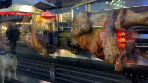 Horizontal 4K video close up. Grilled chicken spins on spit Stock Footage 307649922