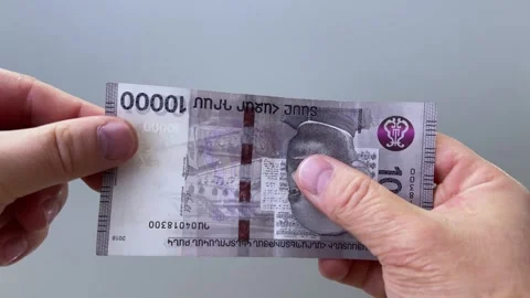 Horizontal 4K video. Man checking watermark on 10000 dram Stock Footage 310397100