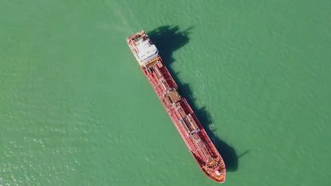 Horizontal aerial top down view of a massive red cargo ship navigating thro.. Stock Photos