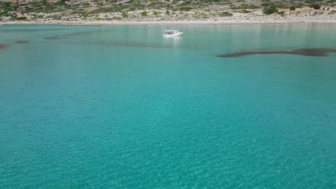 Horizontal aerial view of a small white motorboat anchored in the crystal c.. Stock Photos
