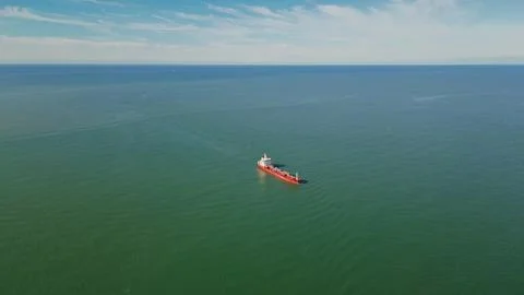 Horizontal aerial wide angle view of a large red oil tanker ship sailing in.. Stock Photos