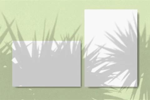 Horizontal and vertical sheets of white textured paper against a green wall Stock Illustration