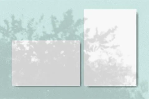 Horizontal and vertical sheets of white textured paper against a blue wall Illustrazione stock