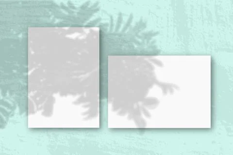 Horizontal and vertical sheets of white textured paper against a pink wall ba Stock Photos