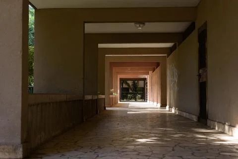 Horizontal architectural perspective view of a long covered concrete corrid.. Stock Photos