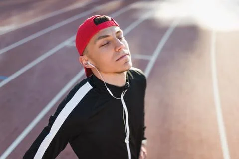 Horizontal bottom view of young handsome athletic man with closed eyes listen Stock Photos