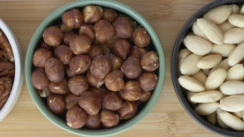 Horizontal camera movement across assorted nuts in ceramic bowls. Almonds Stock Footage 345652145