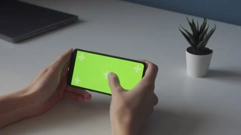 Horizontal chroma key green screen on smartphone in thin hands on white table Stock Footage 167826791