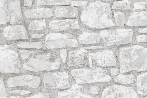 Horizontal close up of a bright white washed stone wall texture featuring r.. Stock Photos