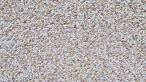 Horizontal close-up of decorative pebble plaster wall with multicolored small Stock Photos