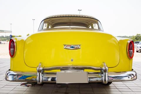 Horizontal close-up image of the back part of an old restored yellow Chevrolet Stock Photos