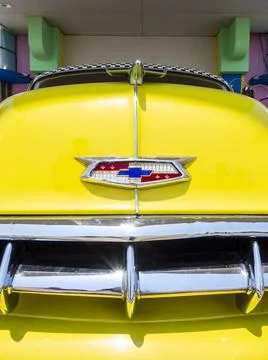 Horizontal close-up image of an old restored yellow Chevrolet with chromed Stock Photos