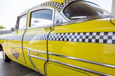 Horizontal close-up lateral image of an old restored yellow Chevrolet cab taxi Stock Photos
