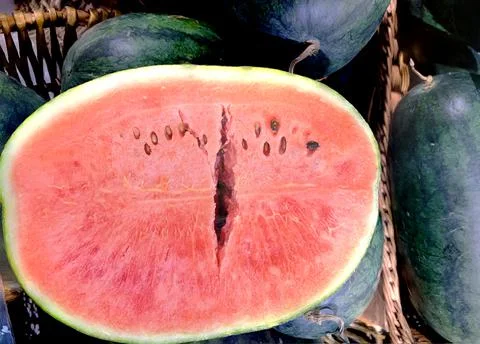 Horizontal close-up one red cut watermelon in the wooden baskets. Stock Photos