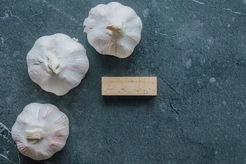 Horizontal close up overhead view of three fresh white garlic bulbs beside .. Stock Photos