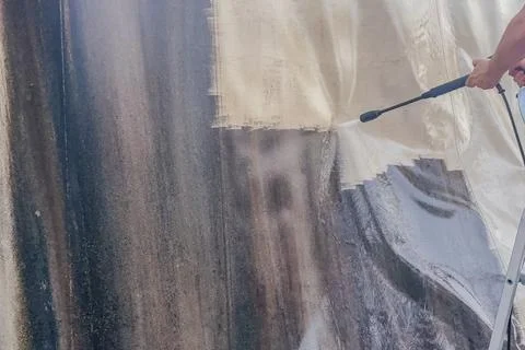 Horizontal close up of a person using a high pressure water power washer to.. Stock Photos