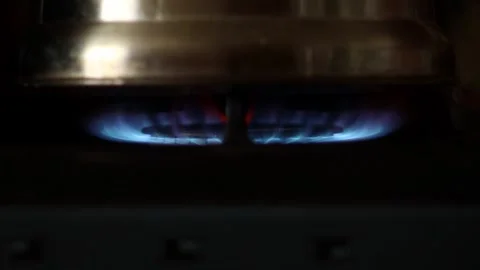 Horizontal close-up shot of a pot heating on a burning gas stove burner wit.. Stock Footage 346881002