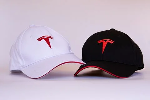 Horizontal close-up of two black and white caps with Tesla logotype in red Stock Photos