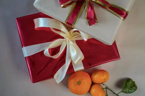 Horizontal Close-Up of Two Gift Boxes with Tangerines on Beige Background Foto stock