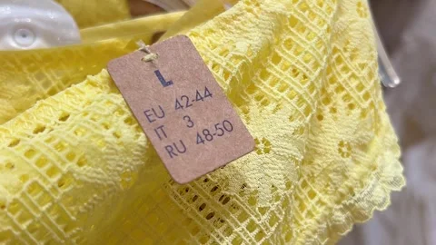 Horizontal close up video. Tag with L designation on yellow lemon panties Stock Footage 314828531