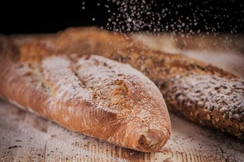 Horizontal closeup view of two fresh crunchy baguettes with raining flour on  Foto stock