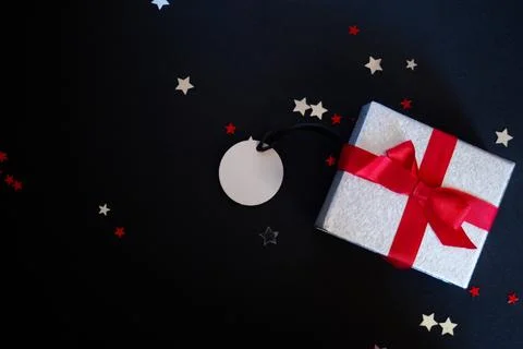 Horizontal dark background with gift box and blank tag.Space for text Stock Photos