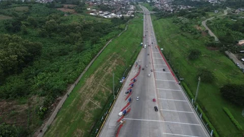 Horizontal drone view of open road section beyond the toll gate with lighter Stock-Footage 306199244