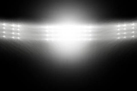 Horizontal floodlight array is casting beams into dark void, making glowing 写真素材