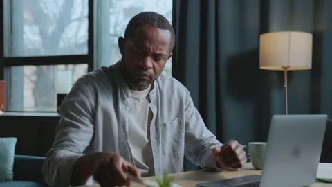 Horizontal footage of working African man in casual outfit taking smartphone and Stock Footage 239457570