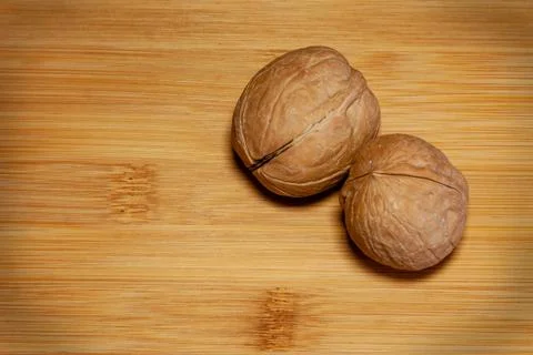 The horizontal frame. Two walnuts lie on a bamboo board Stock Photos