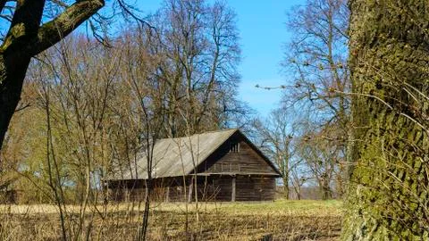 Horizontal image of an old rustic abandoned house and trees on nature backgro Stock Photos