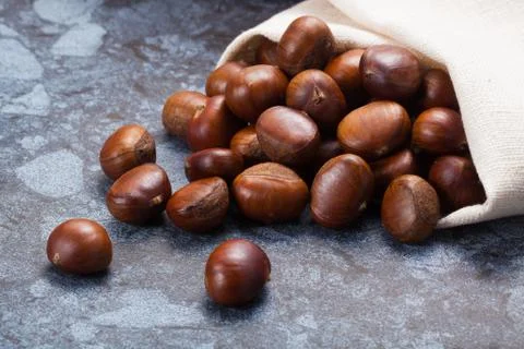 Horizontal image of a pile of chestnuts on stone texture floor with copy spac Stock Photos